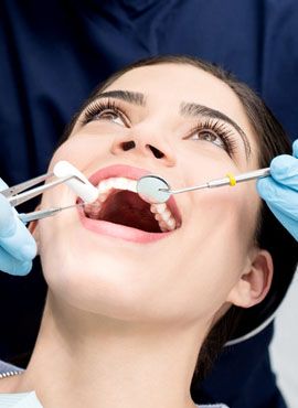 Uśmiechnięty pacjent podczas wykonywanego zabiegu stomatologii zachowawczej